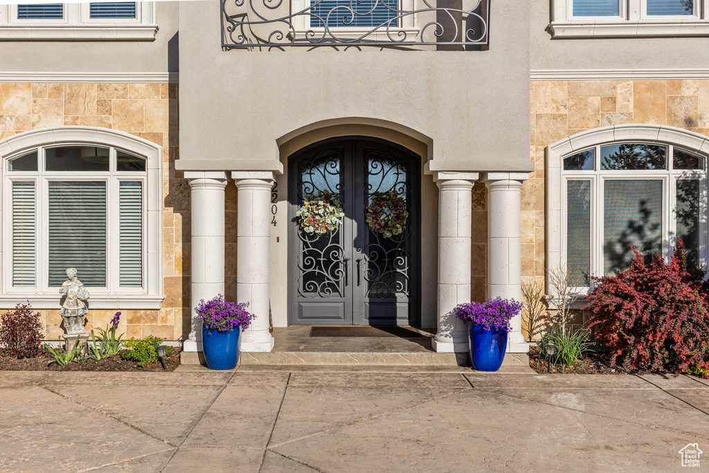 Doorway to property with stone siding and french doors