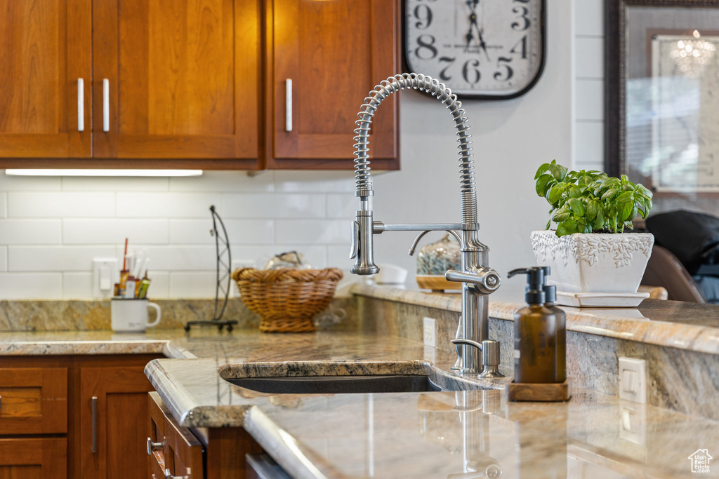 Kitchen with tasteful backsplash, a sink, and brown cabinetry