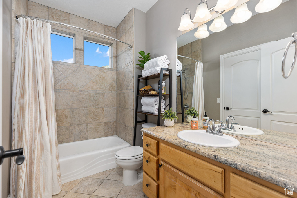 Full bathroom featuring vanity, shower / bath combination with curtain, tile patterned floors, and toilet