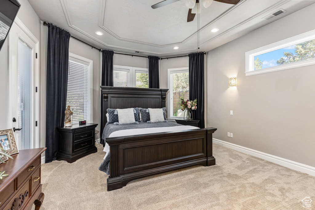 Bedroom featuring light carpet, attic access, multiple windows, recessed lighting, and a tray ceiling
