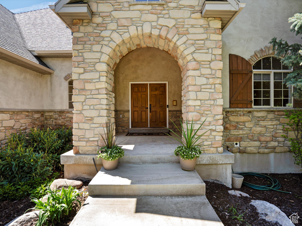Property entrance featuring stone siding and stucco siding