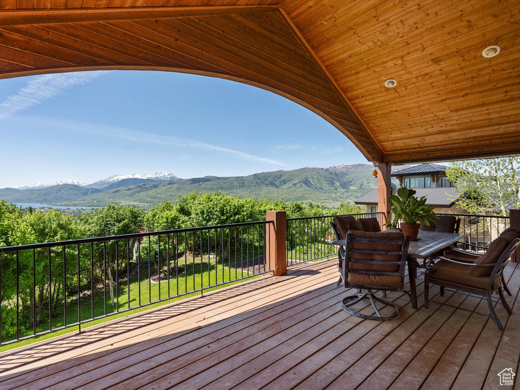 Wooden deck with a mountain view and outdoor dining space
