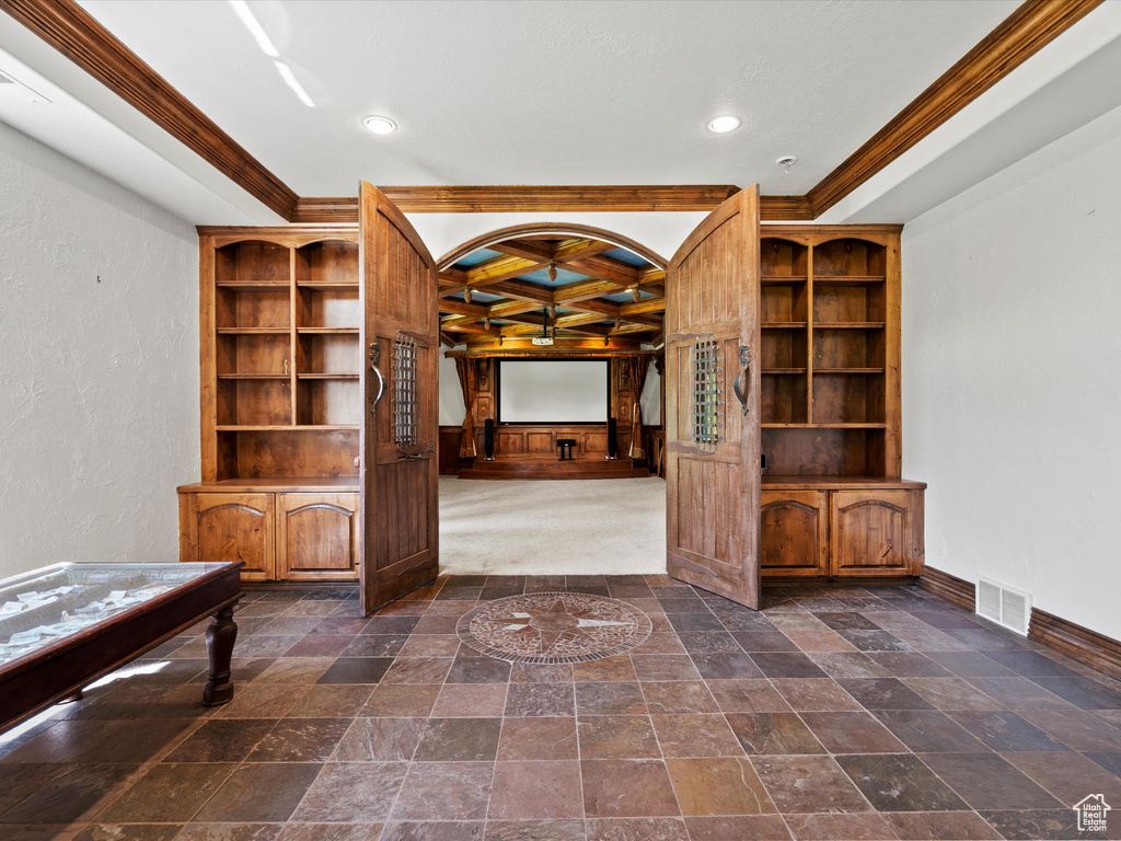 Unfurnished living room with coffered ceiling, crown molding, baseboards, recessed lighting, and dark stone finish flooring