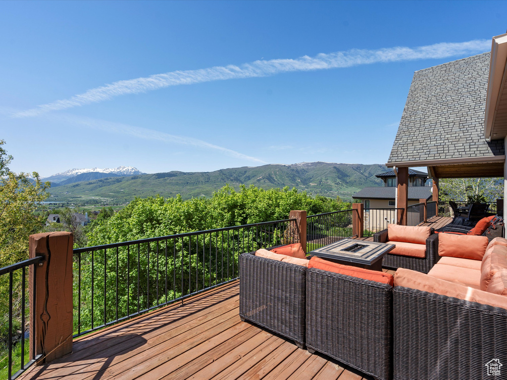 Deck with a mountain view and an outdoor living space with a fire pit