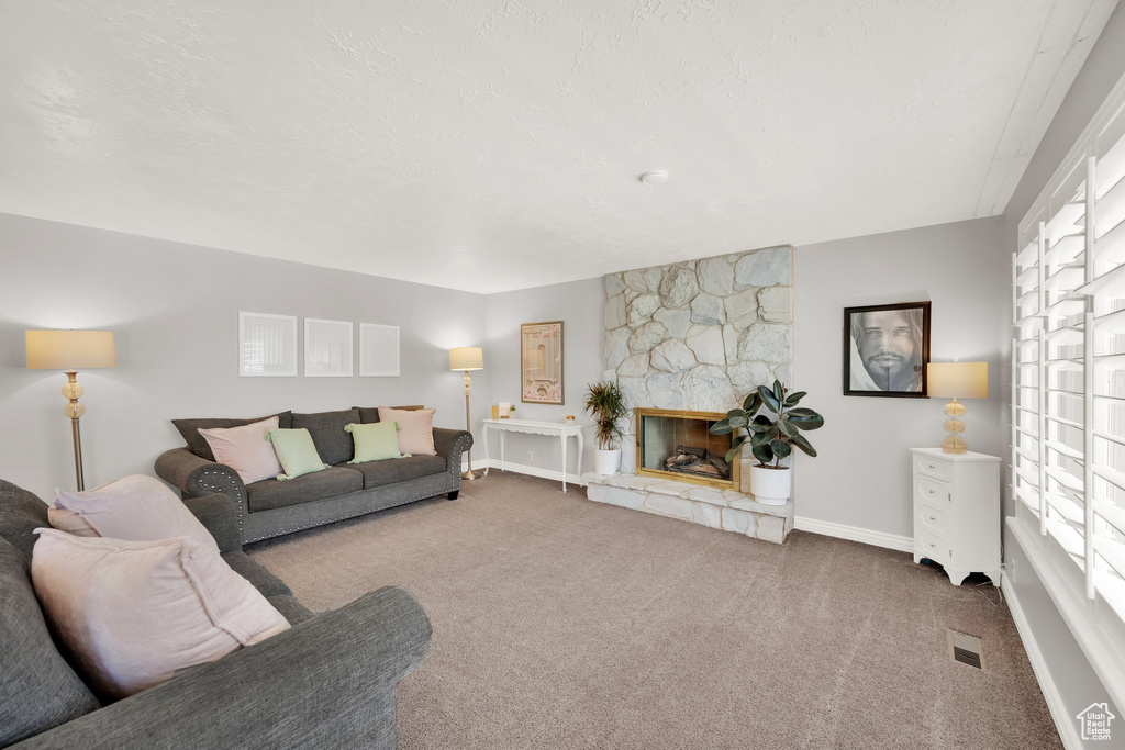 Living room featuring carpet floors, baseboards, and a fireplace