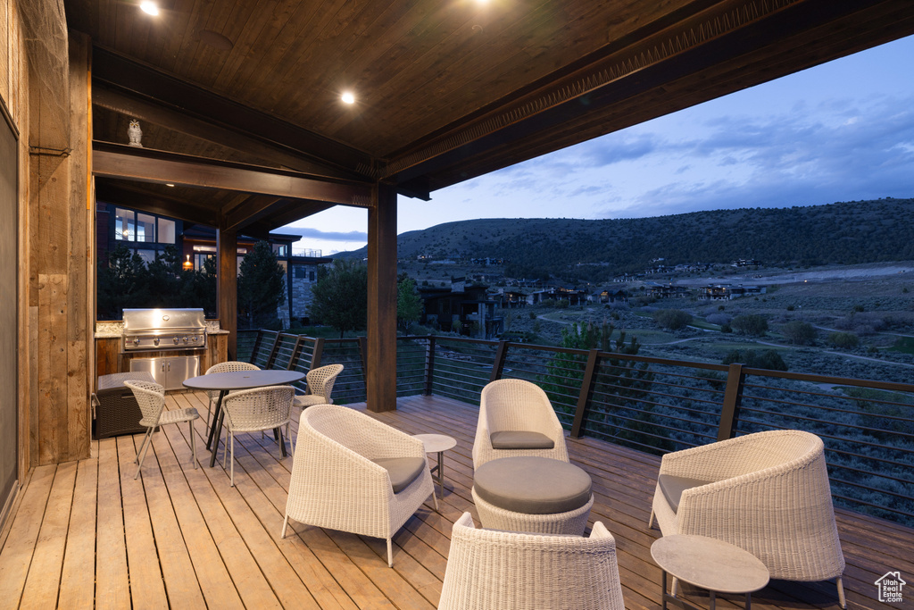 Deck featuring a grill, a mountain view, and outdoor dining area