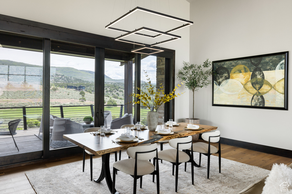 Dining space featuring wood finished floors, a mountain view, baseboards, and a chandelier