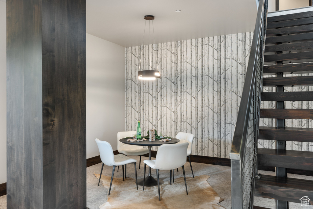 Carpeted dining space with stairway