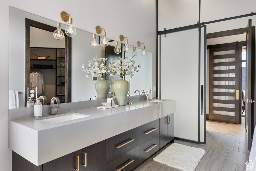 Bathroom featuring double vanity and a walk in closet