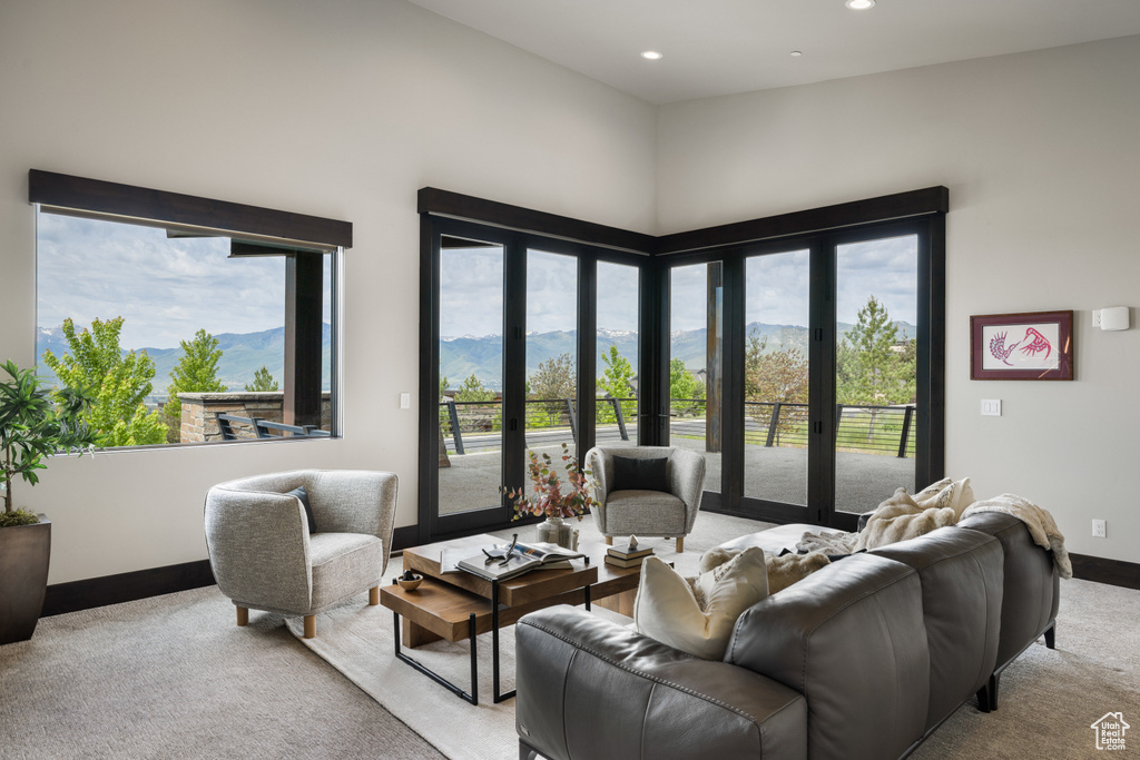 Living room with light colored carpet, a mountain view, baseboards, and recessed lighting