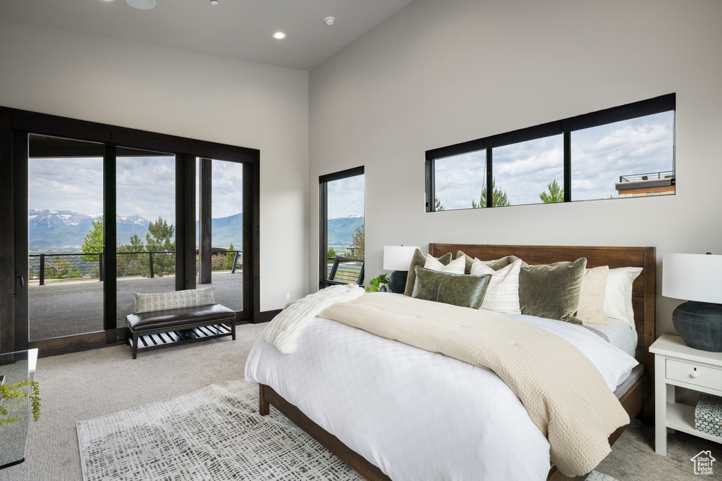 Carpeted bedroom with a high ceiling, recessed lighting, a mountain view, and access to outside