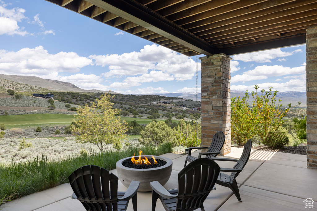 View of patio with a fire pit and a mountain view
