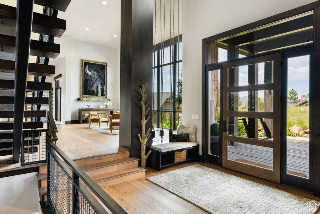 Entryway featuring hardwood / wood-style flooring, plenty of natural light, a high ceiling, and recessed lighting