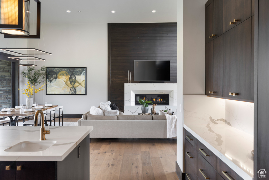 Living room with recessed lighting, light wood-style flooring, a fireplace, and baseboards