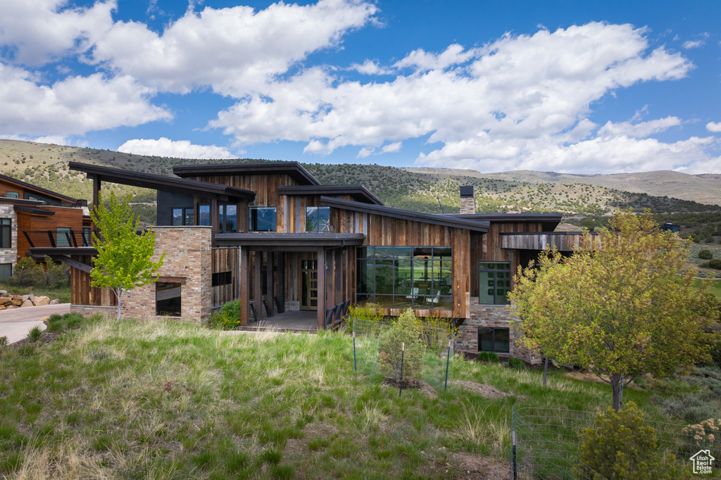 Rear view of property with a mountain view and a chimney
