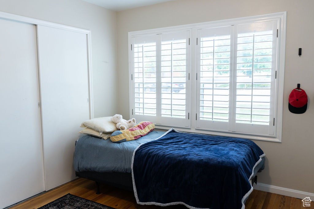 Bedroom featuring wood finished floors, multiple windows, and baseboards