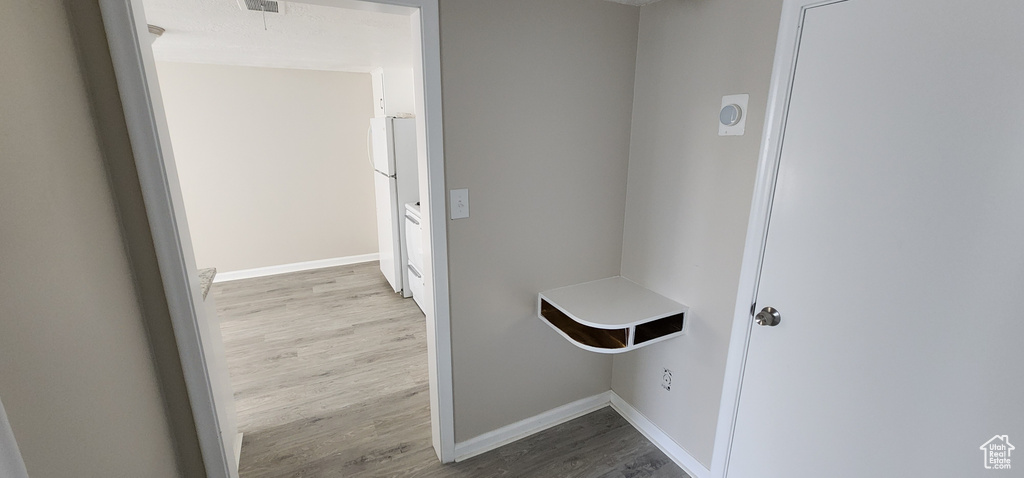 Laundry room with wood finished floors and baseboards