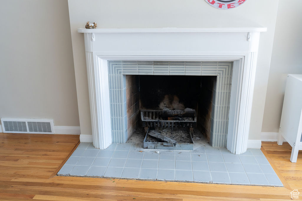 Detailed view of wood finished floors, baseboards, and a tile fireplace