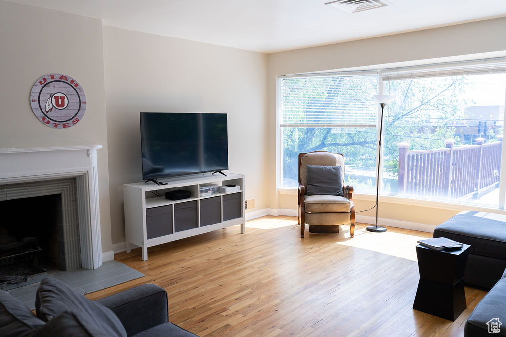 Living area with light wood finished floors, baseboards, and a fireplace