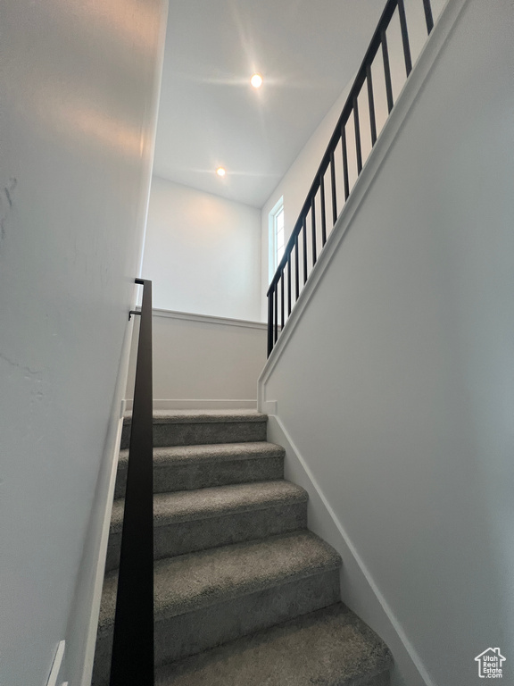 Stairs with recessed lighting and baseboards