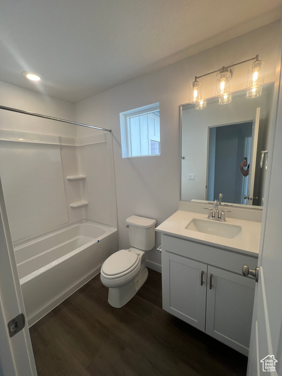 Bathroom featuring toilet, vanity, wood finished floors, bathing tub / shower combination, and recessed lighting