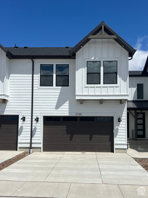 View of front of house featuring an attached garage, board and batten siding, and concrete driveway