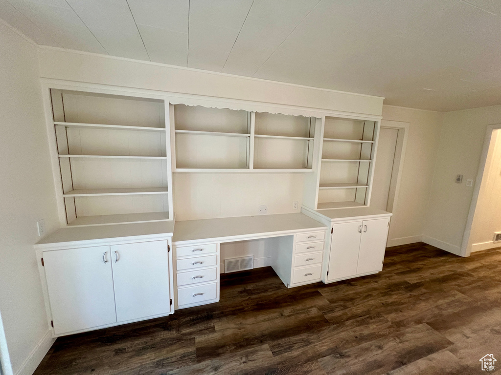 Unfurnished office with dark wood-style floors and baseboards