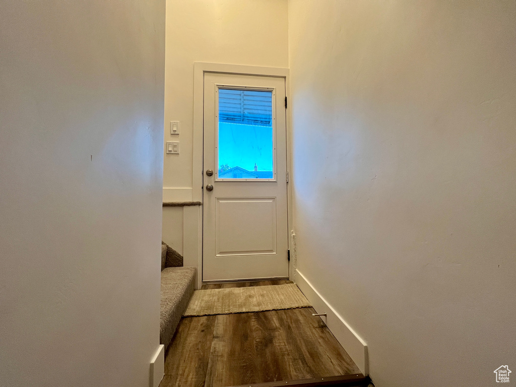 Doorway featuring dark wood-style flooring and baseboards