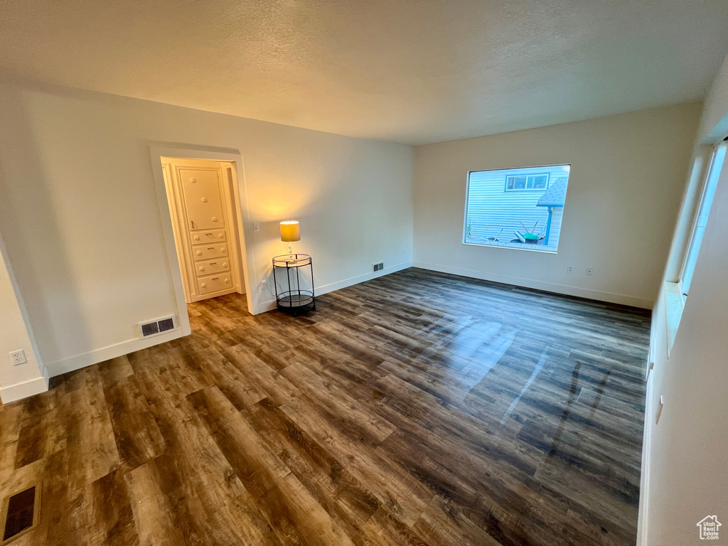 Spare room with dark wood finished floors and baseboards