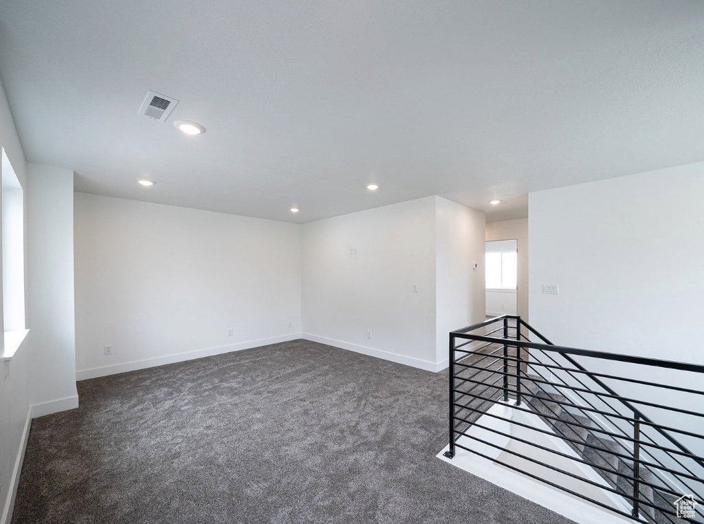 Unfurnished room featuring dark carpet, recessed lighting, and baseboards
