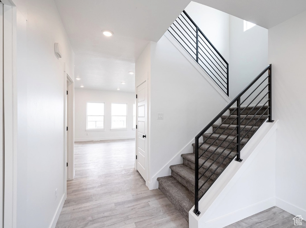 Stairs featuring wood finished floors, baseboards, and recessed lighting