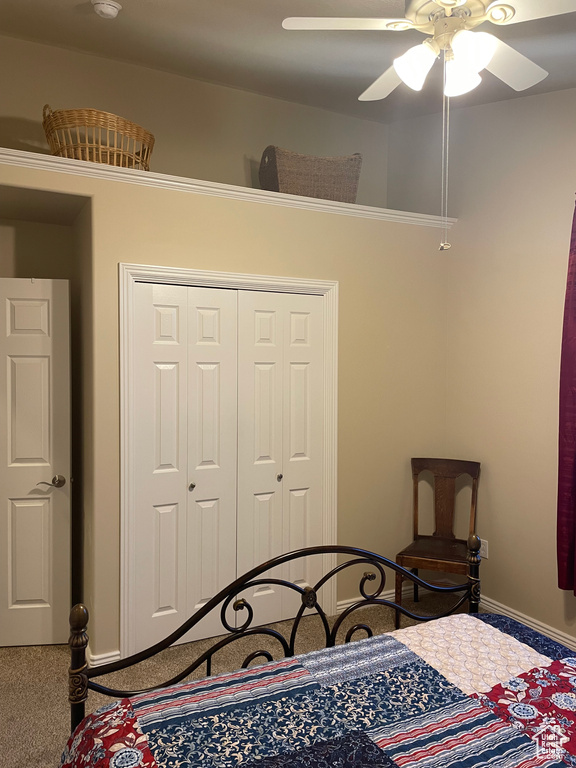 Carpeted bedroom featuring a closet, a ceiling fan, and baseboards