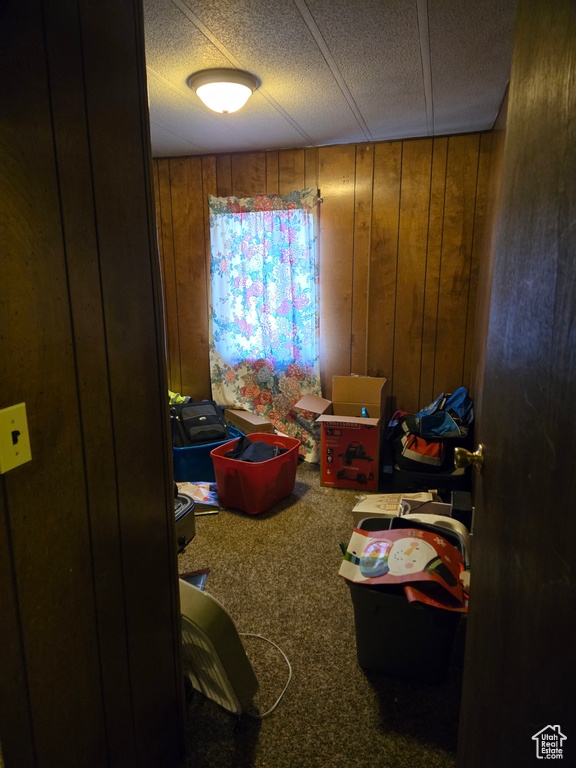 Bedroom with wooden walls and carpet flooring