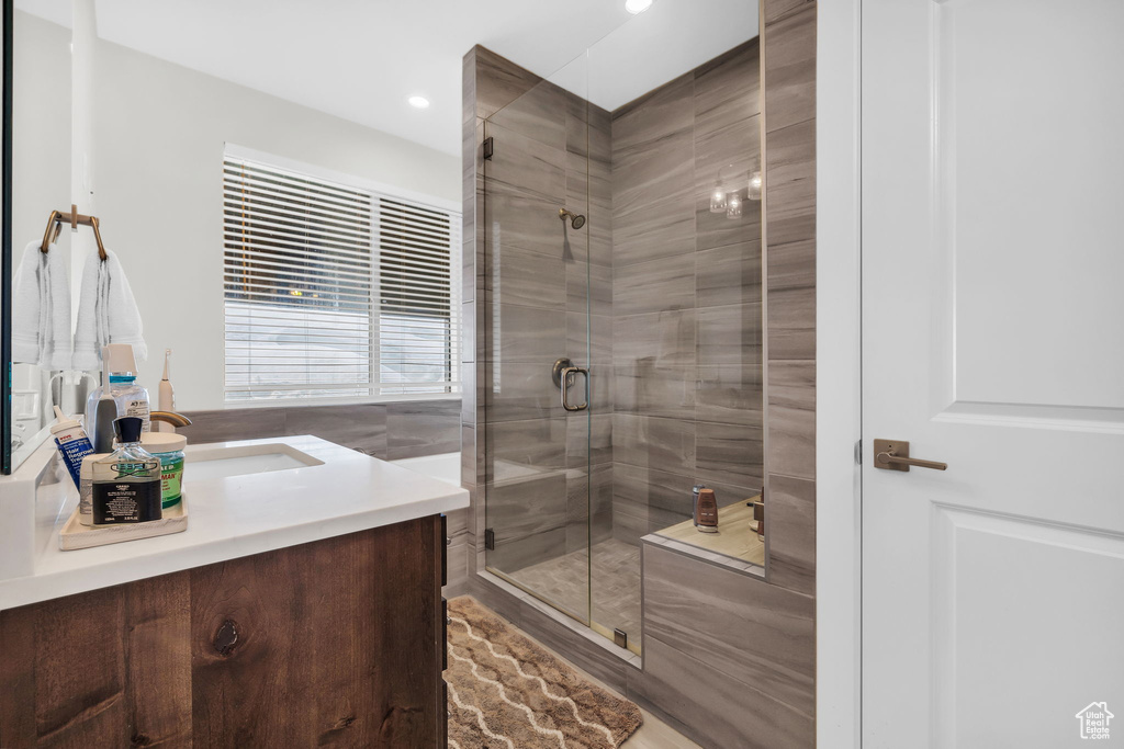 Full bathroom featuring vanity, a stall shower, and recessed lighting