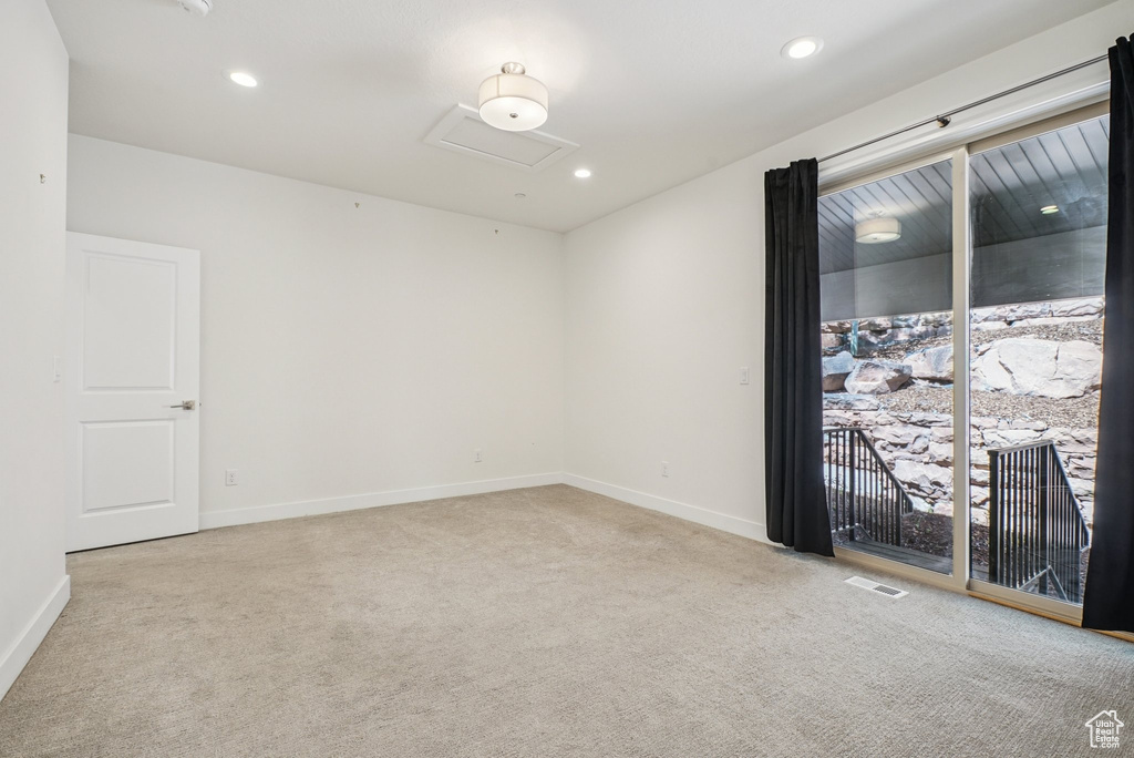 Unfurnished room featuring light carpet, attic access, baseboards, and recessed lighting