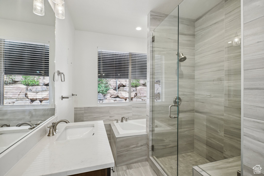 Full bath featuring vanity, a garden tub, a shower stall, plenty of natural light, and recessed lighting