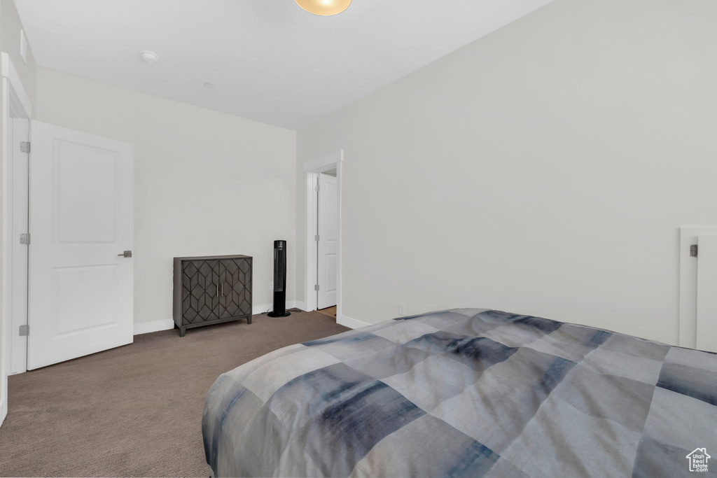 Bedroom featuring carpet and baseboards
