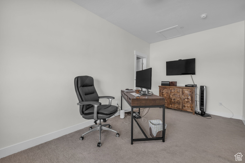 Carpeted office space with attic access and baseboards