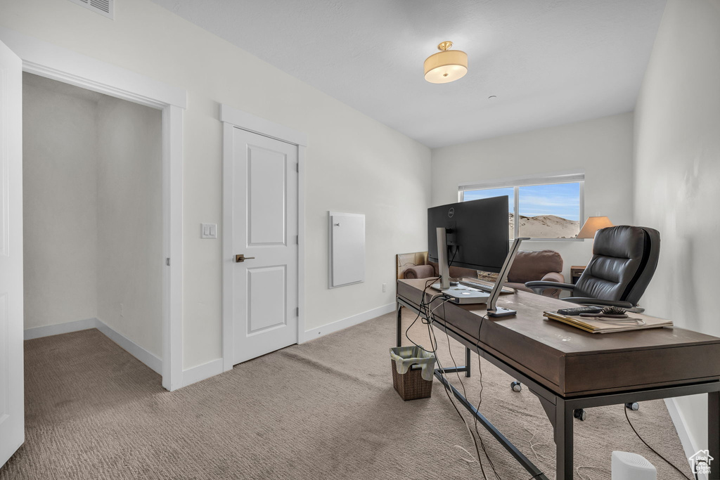 Office with light colored carpet and baseboards