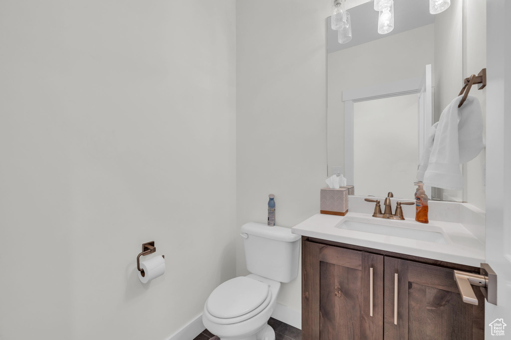 Bathroom featuring toilet, vanity, and baseboards