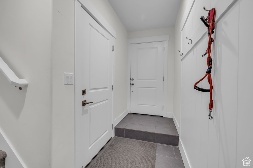 Doorway to outside with tile patterned floors and baseboards