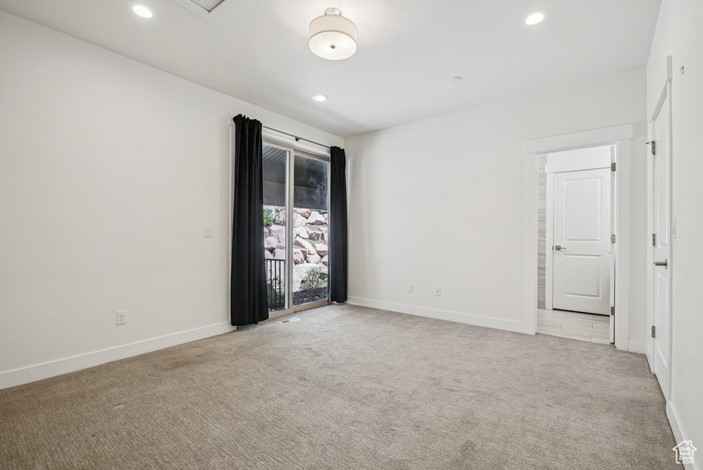 Spare room featuring light carpet, recessed lighting, and baseboards