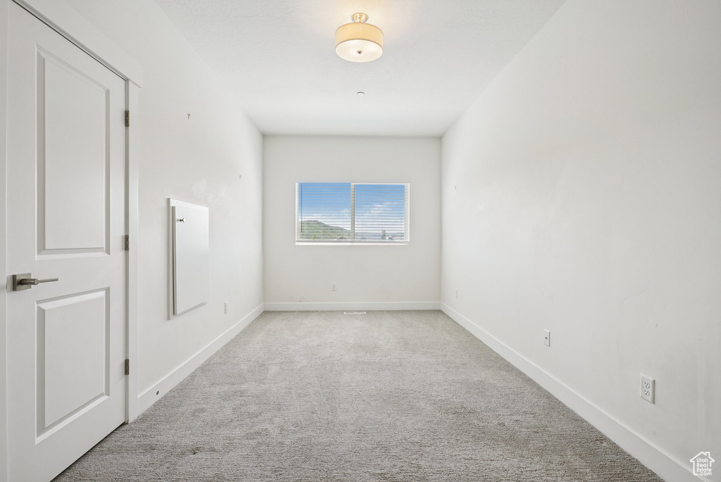 Carpeted spare room with baseboards