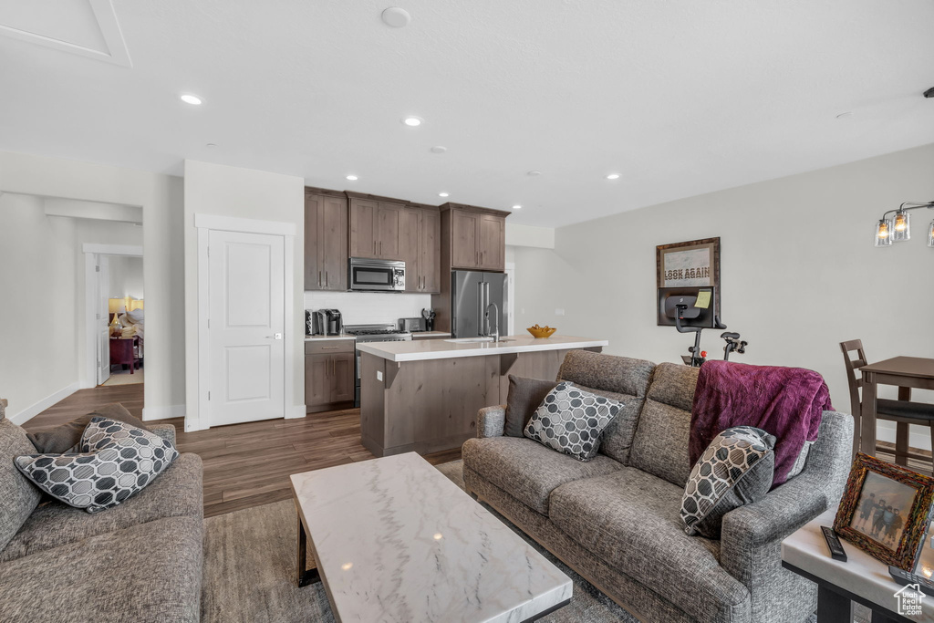 Living room with dark wood finished floors, recessed lighting, and baseboards