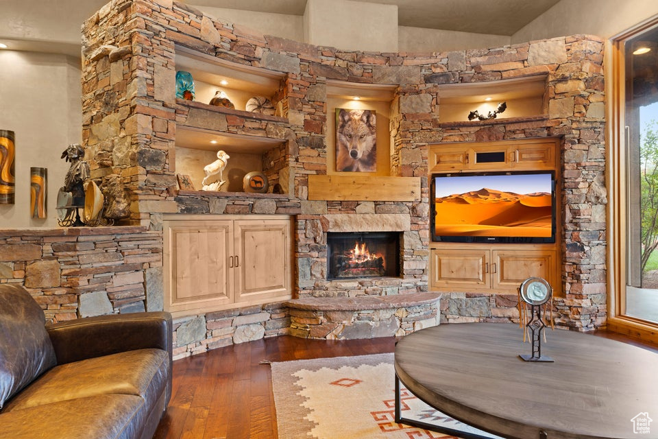 Living area featuring hardwood / wood-style floors, a fireplace, and vaulted ceiling