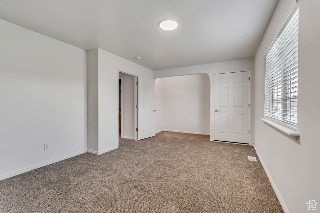 Unfurnished bedroom featuring carpet and baseboards