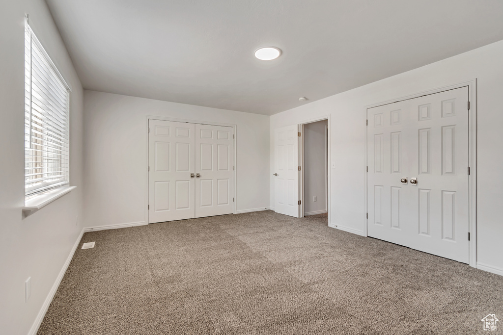 Unfurnished bedroom featuring carpet and baseboards