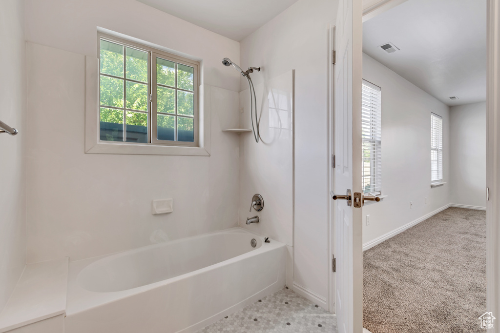 Full bathroom featuring plenty of natural light, bathtub / shower combination, and baseboards