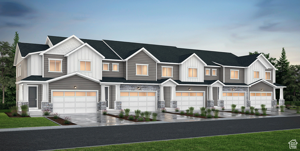 View of property featuring board and batten siding, stone siding, an attached garage, driveway, and roof with shingles