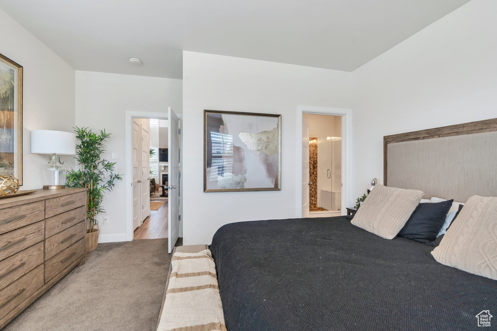 Carpeted bedroom featuring ensuite bathroom